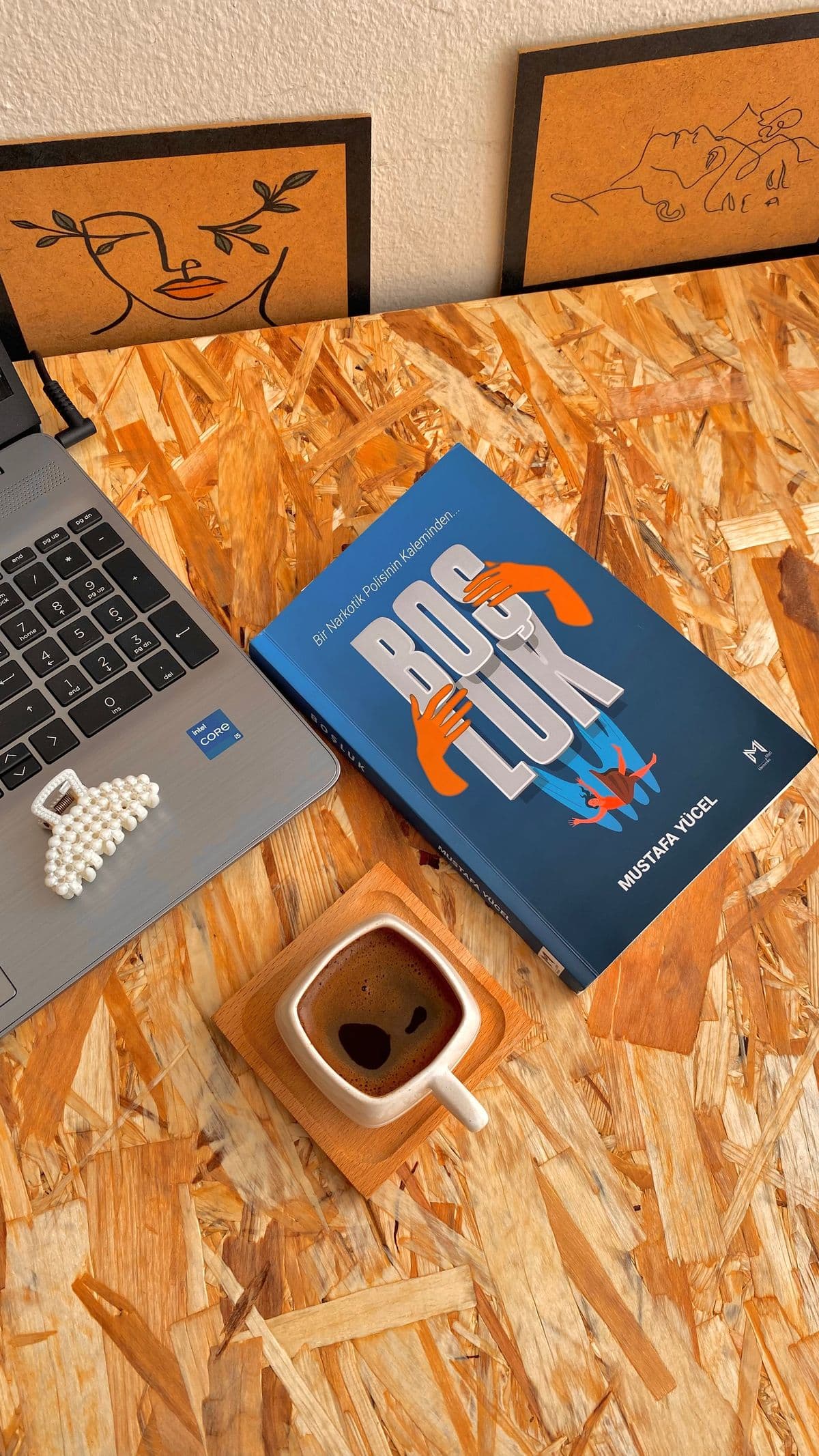 A book, coffee, and laptop on a writer's workspace