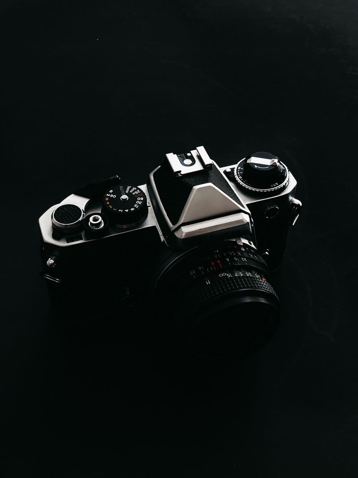 A vintage SLR film camera on a black background