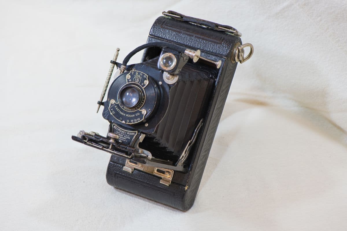 An antique folding camera on a light background