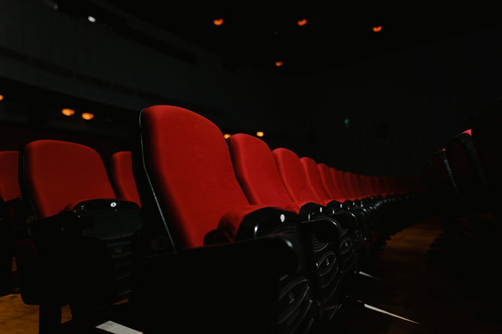 Rows of empty cinema theater seats in a dark screening room