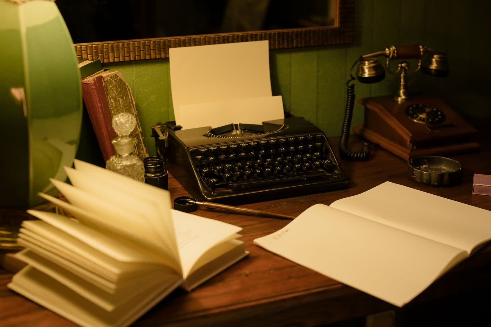 A vintage typewriter and writing desk lit by warm lamplight