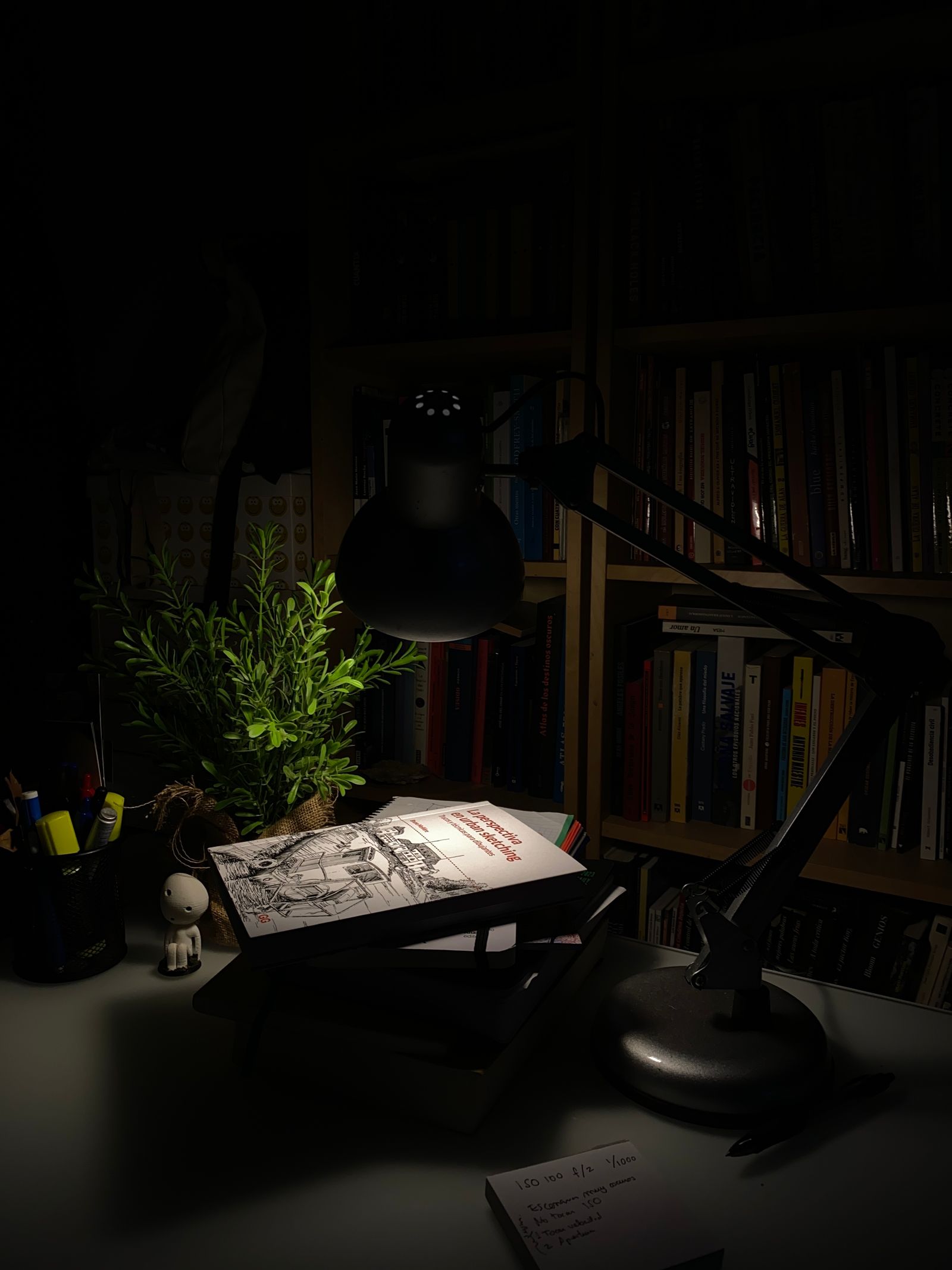 A quiet writer's desk with a lamp, notebook, and typewriter